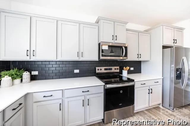 a kitchen with granite countertop white cabinets and stainless steel appliances