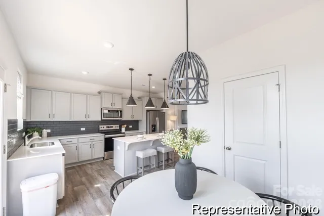 a view of a kitchen with a sink a microwave and cabinets