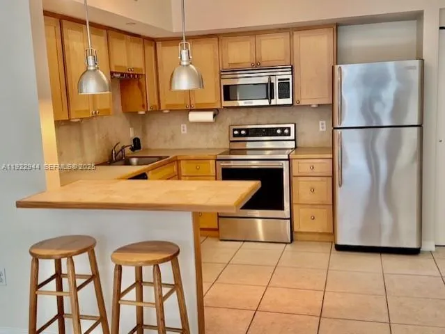 a kitchen with stainless steel appliances a stove a sink and a refrigerator