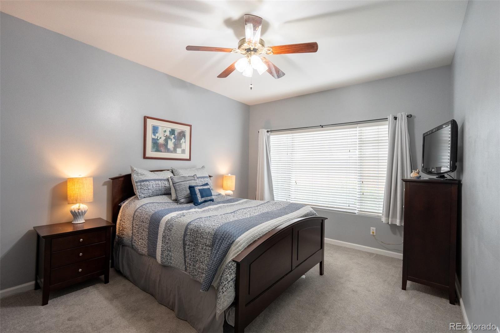 8495 Pebble Creek Way, Unit 102 Highlands Ranch, CO 80126 - Photo 11 of 22 a bedroom with a bed and a chandelier