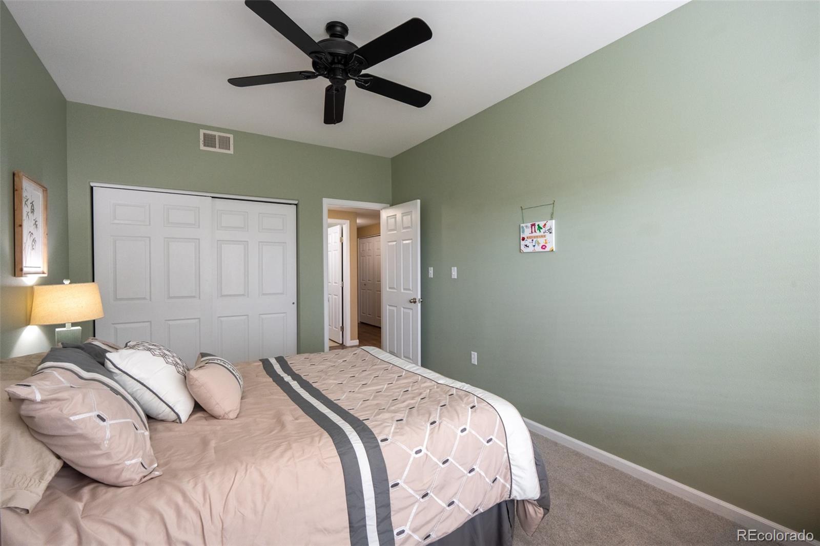 8495 Pebble Creek Way, Unit 102 Highlands Ranch, CO 80126 - Photo 17 of 22 a bedroom with a bed and a painting on the wall