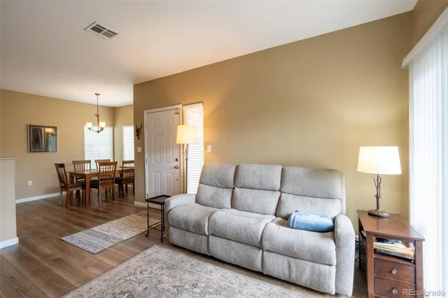 a living room with furniture a lamp on table and a window