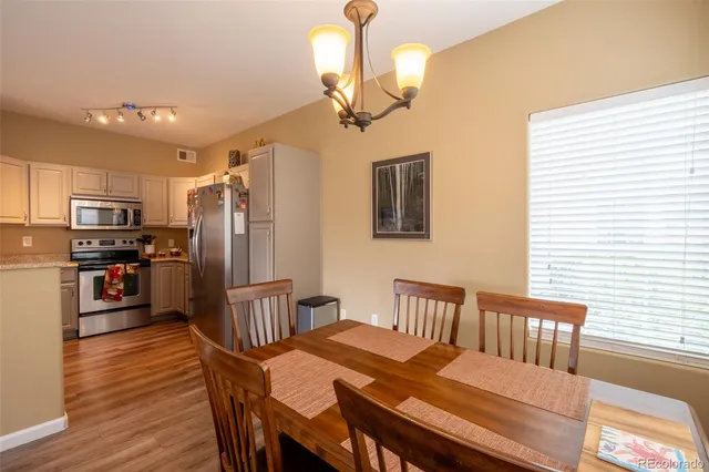 a kitchen with stainless steel appliances kitchen island granite countertop a refrigerator a stove a sink dishwasher with a dining table and chairs