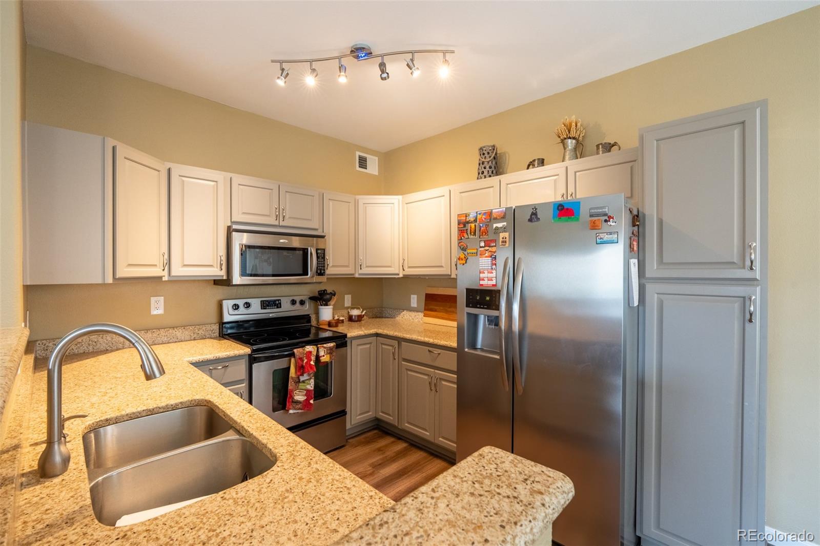8495 Pebble Creek Way, Unit 102 Highlands Ranch, CO 80126 - Photo 8 of 22 a kitchen with stainless steel appliances granite countertop a sink dishwasher a refrigerator and a stove