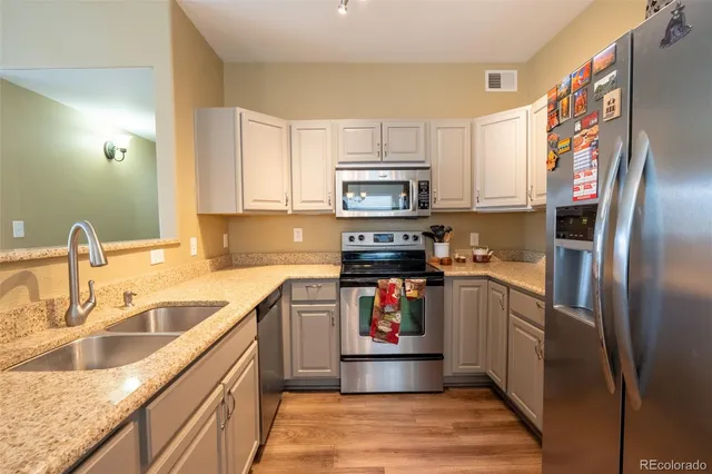 a kitchen with stainless steel appliances granite countertop a refrigerator and a sink
