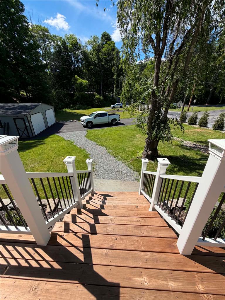 164 Sand Spring Road Cresco, PA 18326 - Photo 16 of 60 Descend wood steps to a sprawling yard with a gravel driveway leading to a detached garage.