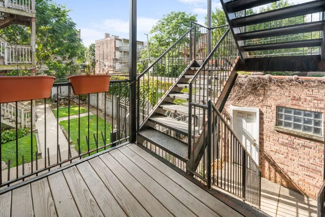 a view of a balcony with wooden floor and iron fence