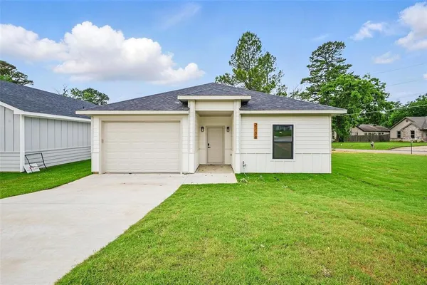 a view of a house with a yard and garage