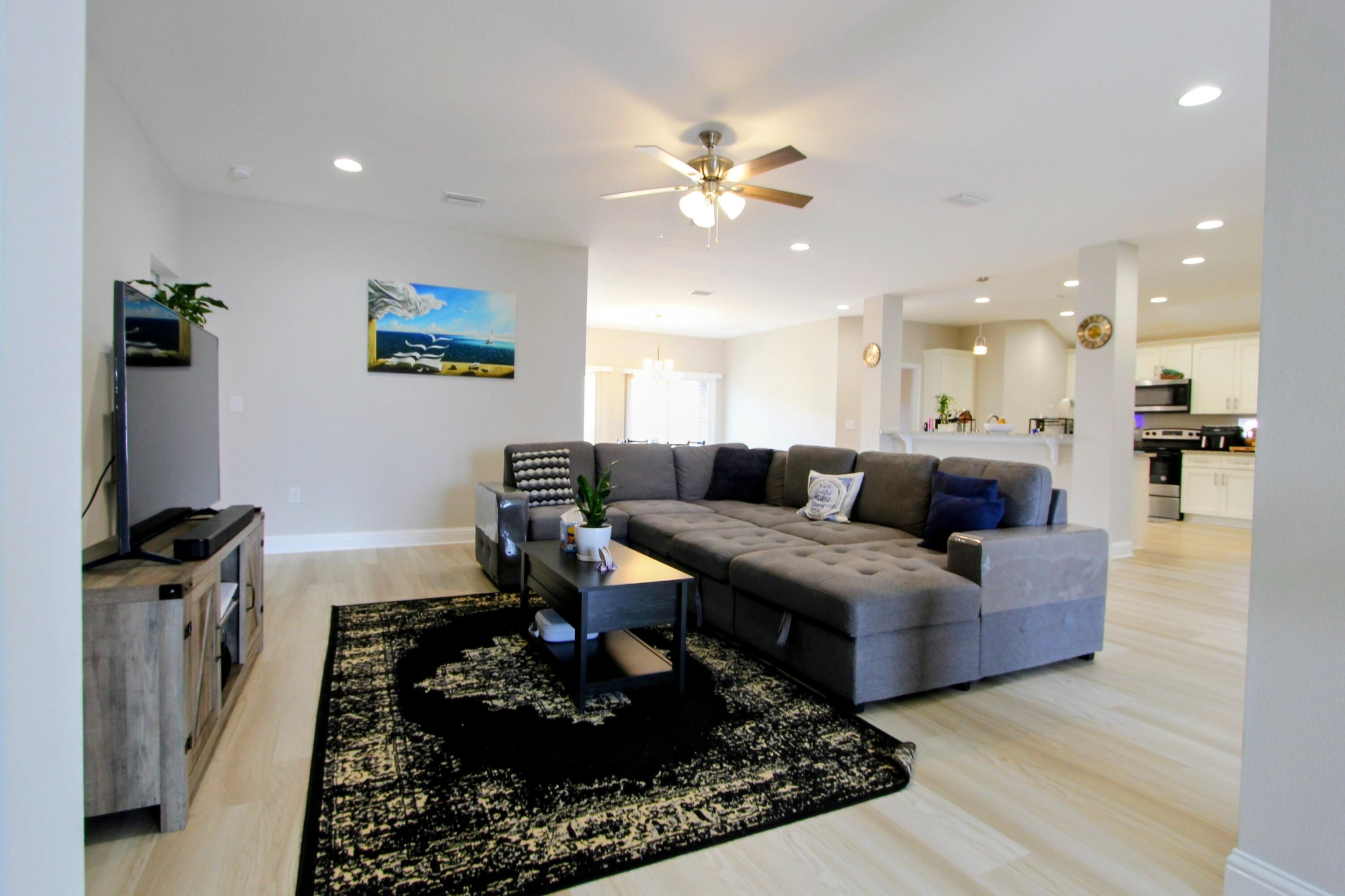 5438 Lee Farm Boulevard Crestview, FL 32536 - Photo 11 of 50 a living room with furniture and a chandelier