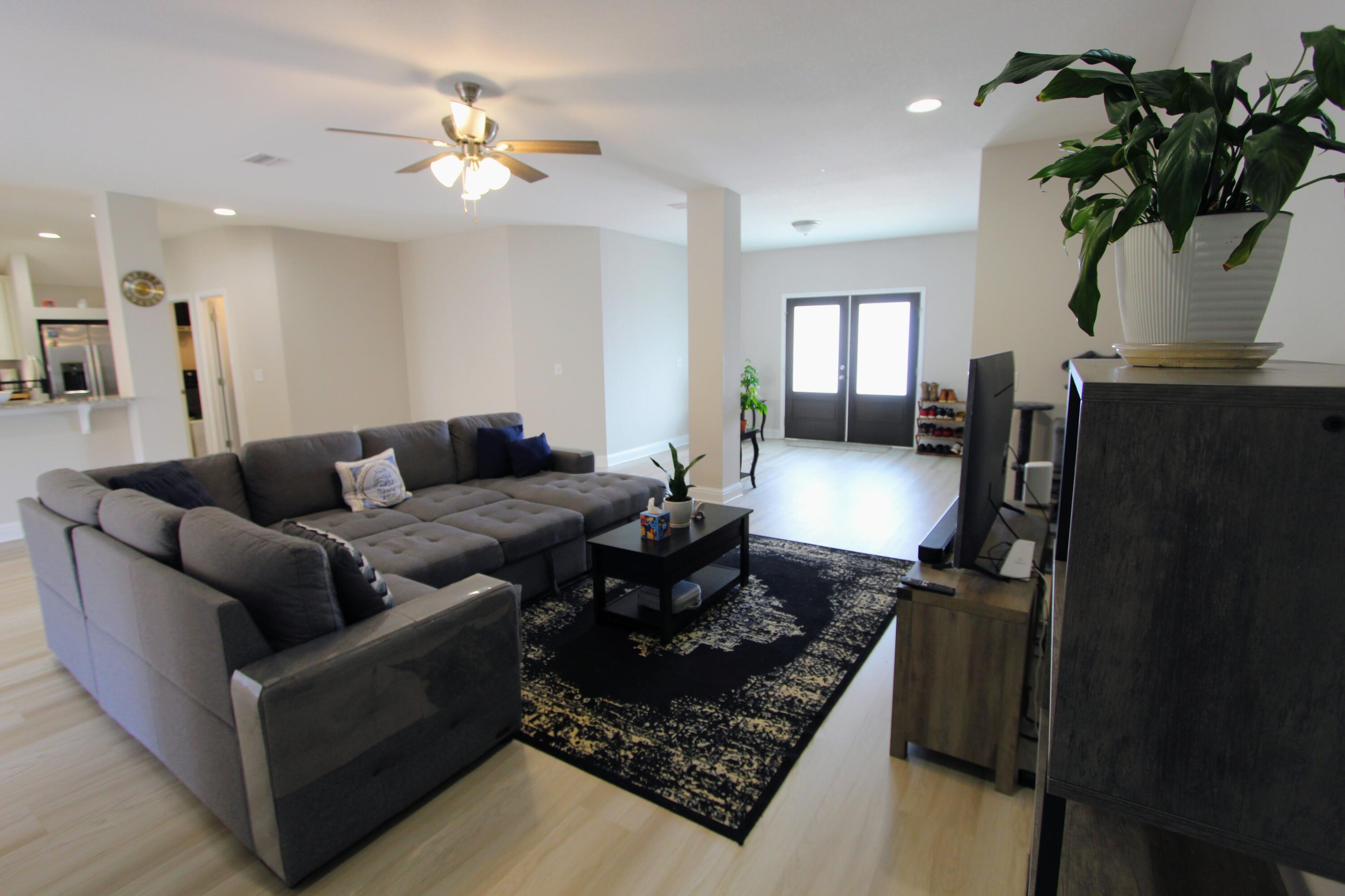 5438 Lee Farm Boulevard Crestview, FL 32536 - Photo 16 of 50 a living room with furniture flowerpot and a chandelier