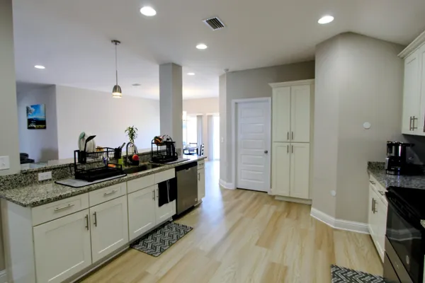 a kitchen with a sink and wooden floor