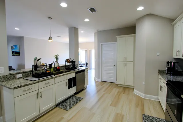a kitchen with a sink and wooden floor