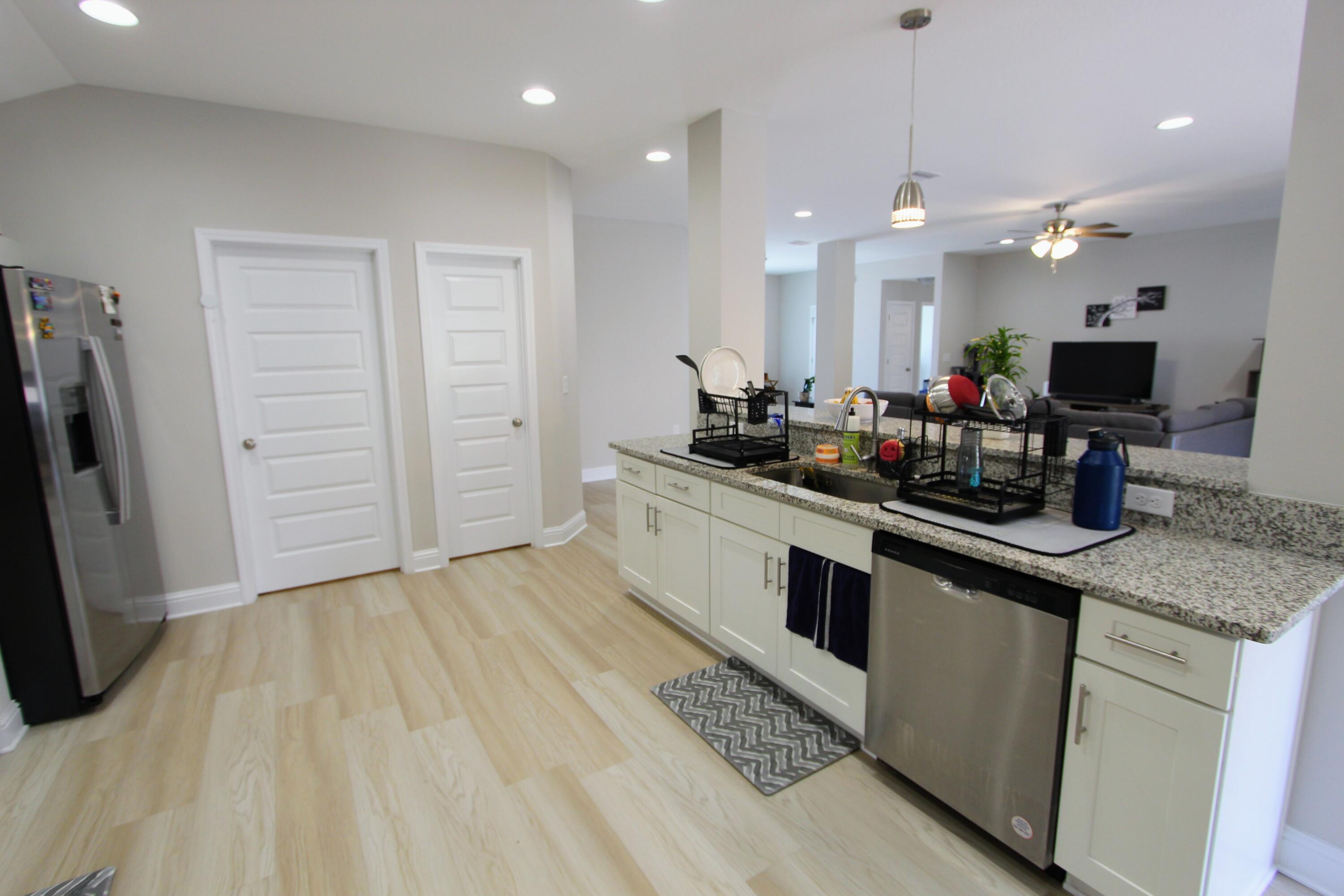 5438 Lee Farm Boulevard Crestview, FL 32536 - Photo 21 of 50 a kitchen with stainless steel appliances kitchen island granite countertop a sink cabinets and wooden floor