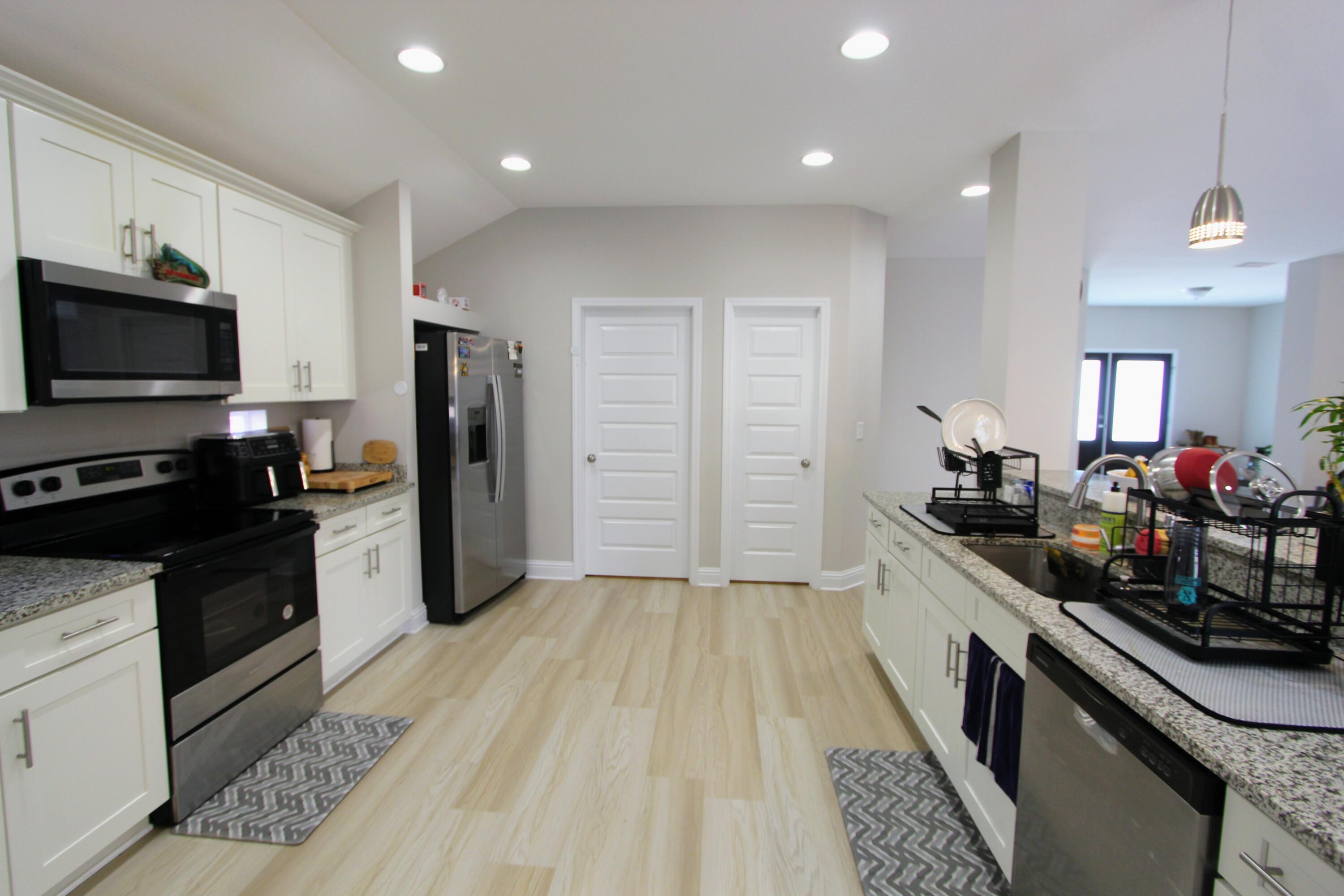 5438 Lee Farm Boulevard Crestview, FL 32536 - Photo 22 of 50 a kitchen with stainless steel appliances a stove top oven a sink dishwasher a refrigerator and a microwave