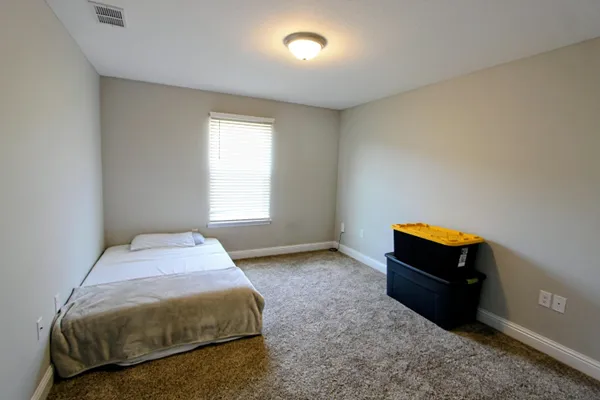 a bedroom with a bed and a window