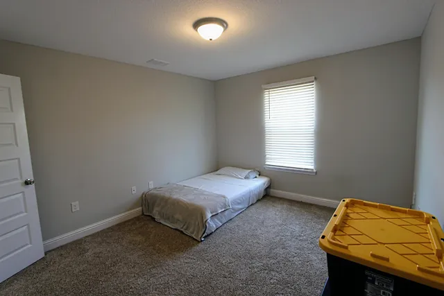 a bedroom with a bed and a window