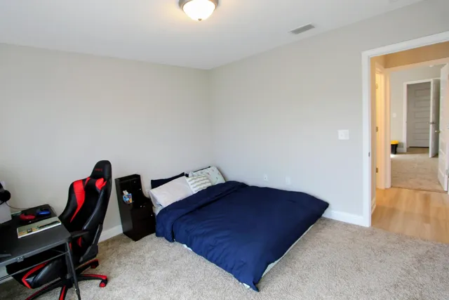 a bedroom with a bed and a wooden floor