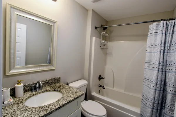 a bathroom with a granite countertop sink toilet and shower
