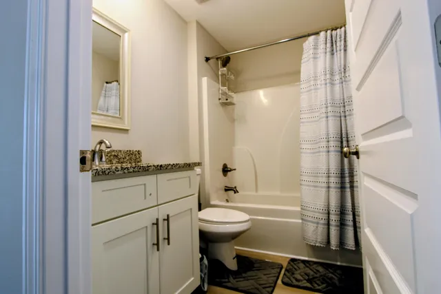 a bathroom with a granite countertop sink toilet and shower
