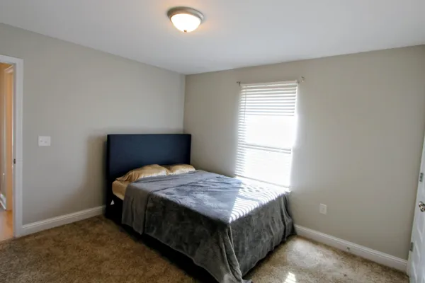 a bedroom with a bed and a window