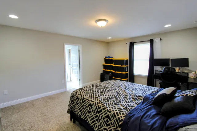 a bedroom with a bed and dresser with mirror