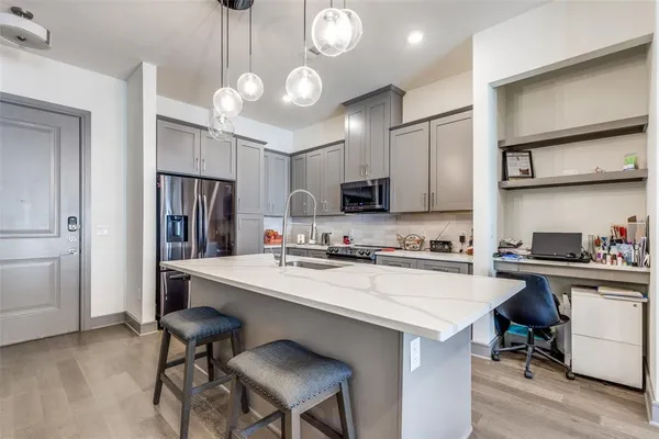 a kitchen with a dining table cabinets appliances and wooden floor