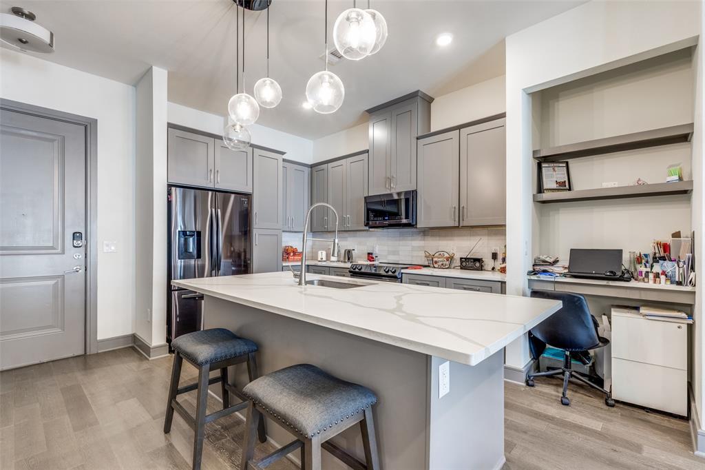 2700 Old Denton Road, Unit 2203 Carrollton, TX 75007 - Photo 6 of 13 a kitchen with a dining table cabinets appliances and wooden floor