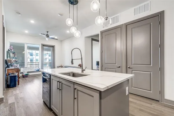 a open kitchen with stainless steel appliances granite countertop a sink and dishwasher with wooden floor