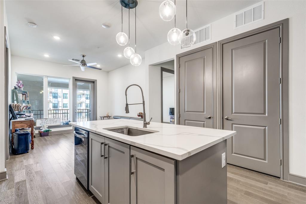 2700 Old Denton Road, Unit 2203 Carrollton, TX 75007 - Photo 7 of 13 a open kitchen with stainless steel appliances granite countertop a sink and dishwasher with wooden floor