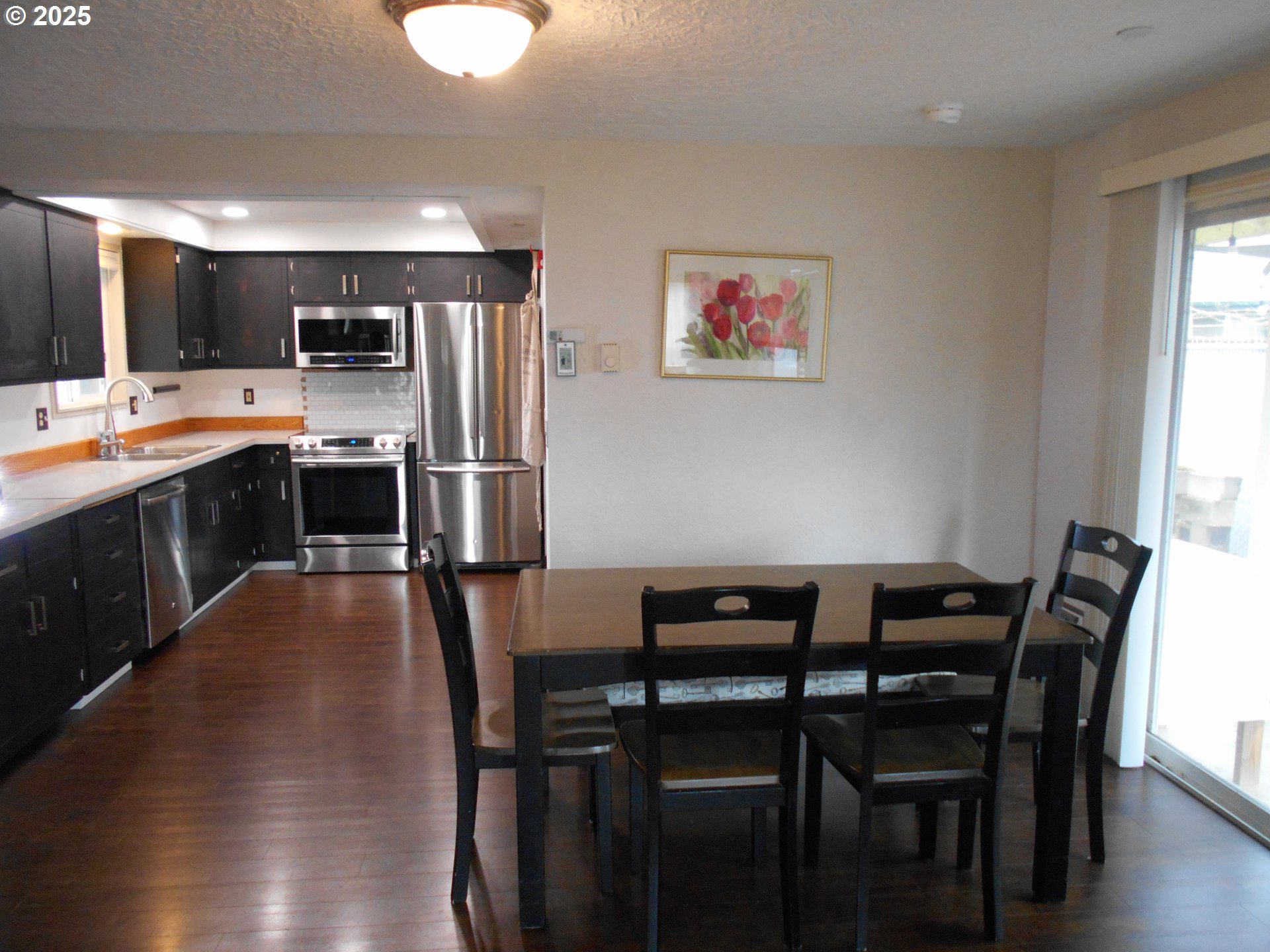 4565 Souza Street Eugene, OR 97402 - Photo 19 of 43 a kitchen with stainless steel appliances kitchen island granite countertop a dining table chairs and granite counter tops