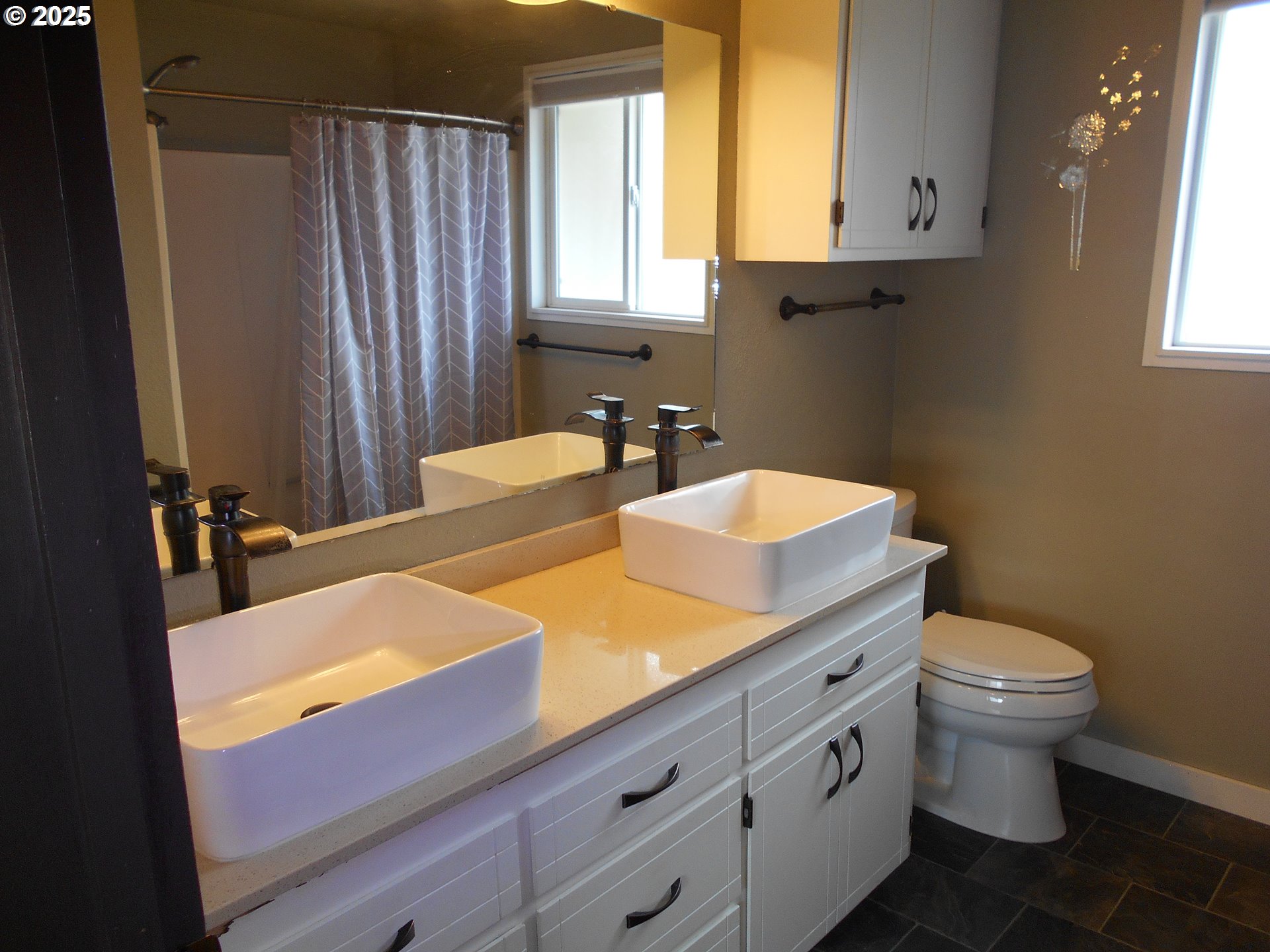 4565 Souza Street Eugene, OR 97402 - Photo 32 of 43 a bathroom with a granite countertop sink mirror vanity and toilet
