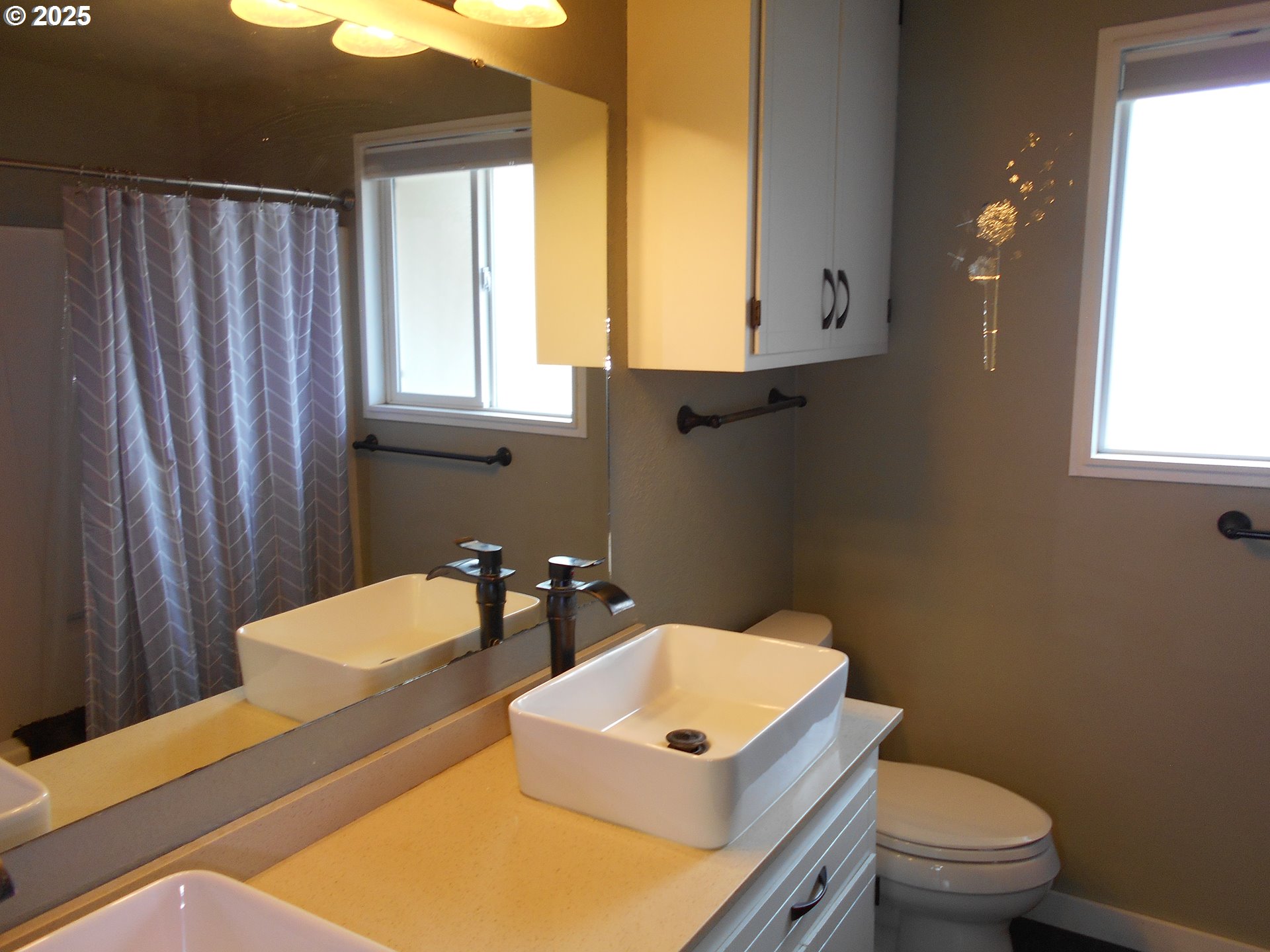 4565 Souza Street Eugene, OR 97402 - Photo 33 of 43 a bathroom with a toilet a sink and a mirror