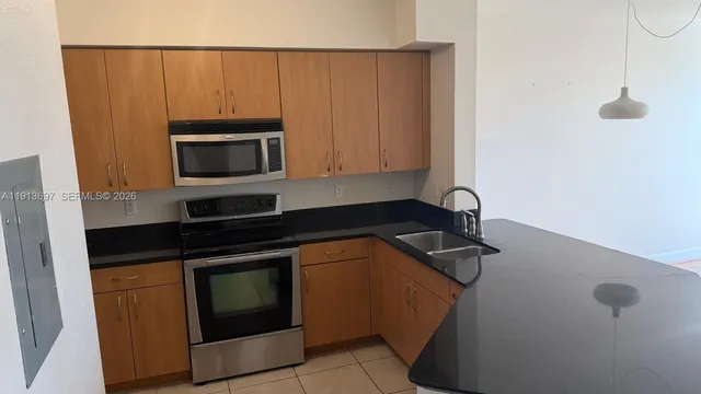 a kitchen with granite countertop cabinets stainless steel appliances and a counter space