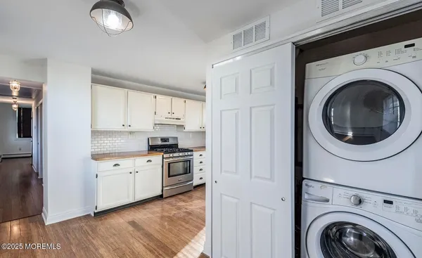 a kitchen with cabinets stainless steel appliances and wooden floors