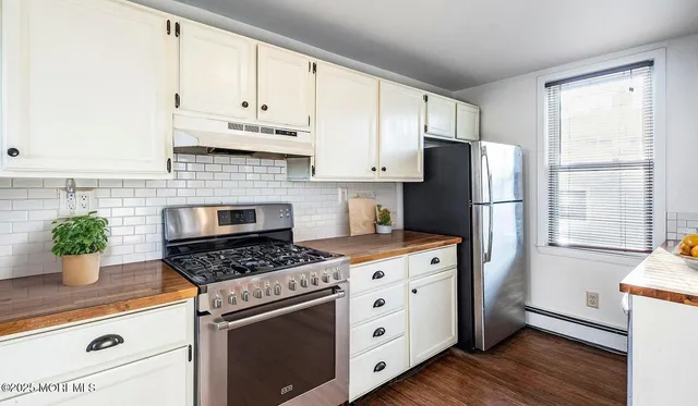 a kitchen with a refrigerator a stove a microwave and cabinets