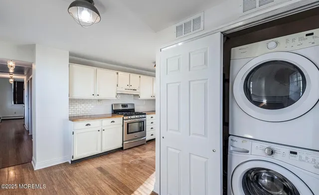 a kitchen with cabinets stainless steel appliances and wooden floors