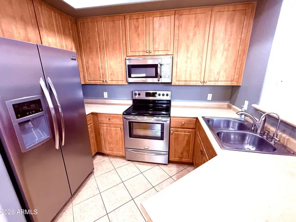 a kitchen with granite countertop a refrigerator and a sink