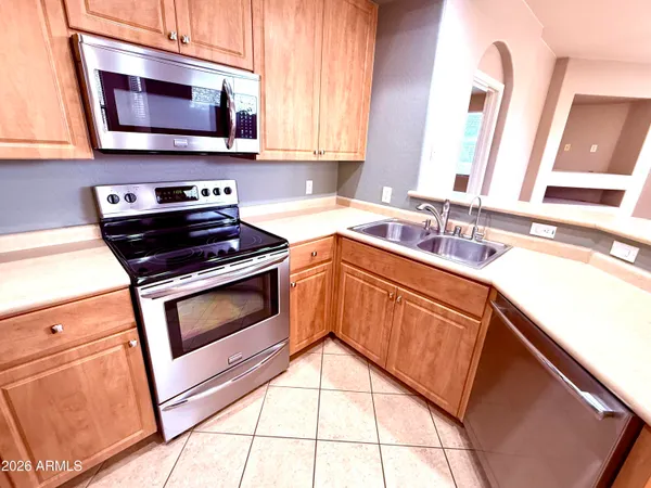 a kitchen with stainless steel appliances a stove microwave and sink