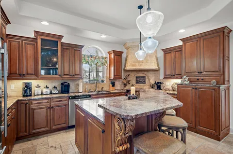 a kitchen with stainless steel appliances granite countertop a sink a stove and a wooden floors