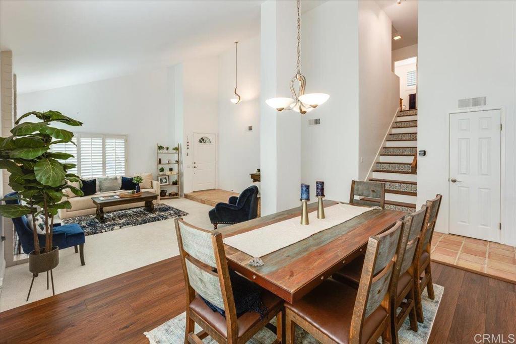 13411 Appalachian Way San Diego, CA 92129 - Photo 4 of 12 a dining room with wooden floor a chandelier a wooden table and chairs