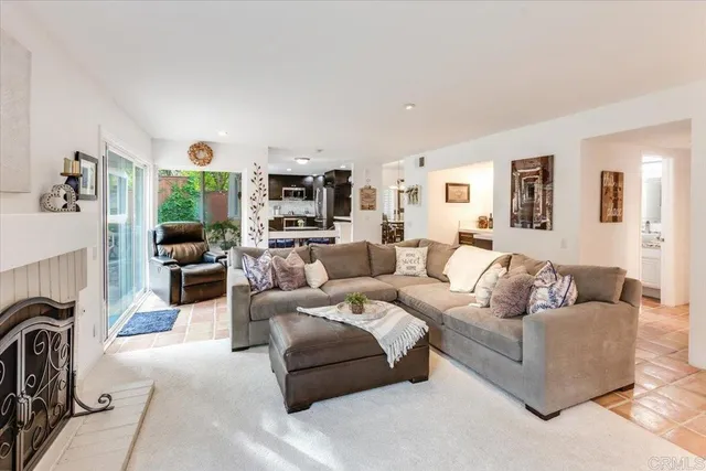 a living room with furniture a fireplace and a large window