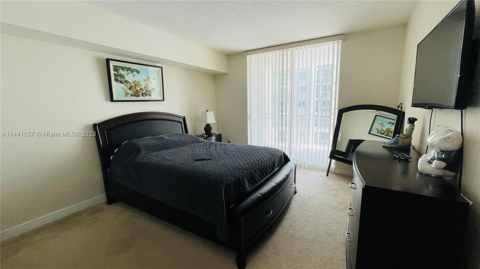 West Flagler Miami, FL 33125 - Photo 20 of 28 a bedroom with a bed and a flat tv screen on the dresser