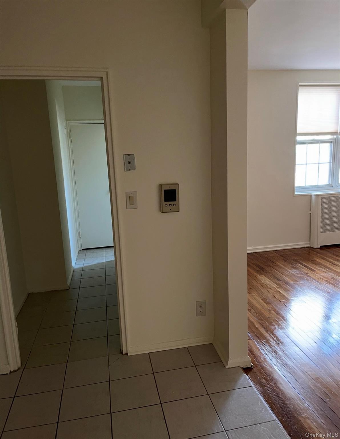 776 Bronx River Road, Unit B24 Bronxville, NY 10708 - Photo 6 of 9 Corridor with light tile patterned floors and radiator heating unit