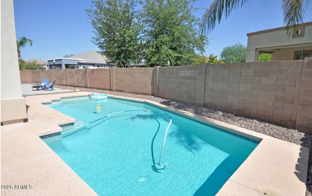 a view of a backyard with a small pool and sitting area