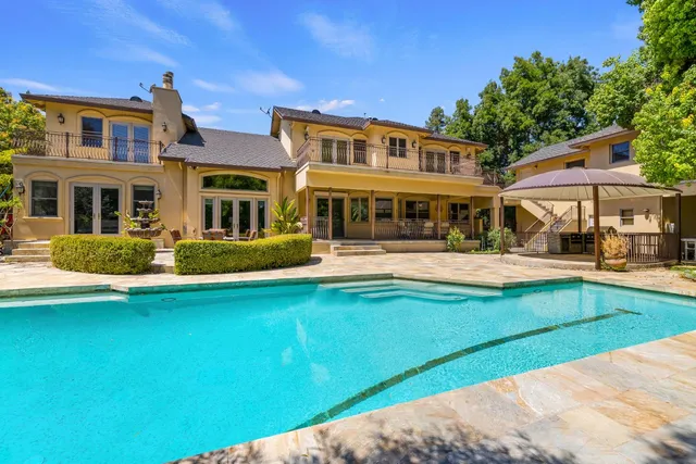 an aerial view of a house with swimming pool garden and patio