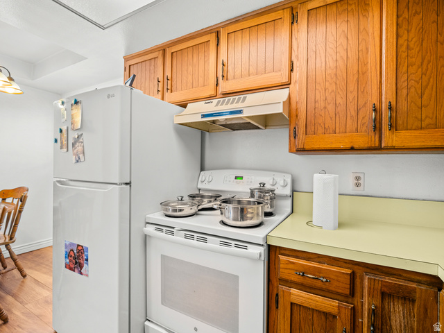460 200 South Provo, UT 84606 - Photo 39 of 66 Kitchen with white appliances, light countertops, wood finish cabinets, and light wood-type flooring