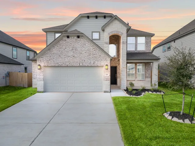 a front view of a house with a yard and garage
