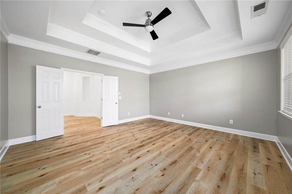 3628 Ashcroft Bend Atlanta, GA 30319 - Photo 27 of 44 an empty room with wooden floor ceiling fan and windows