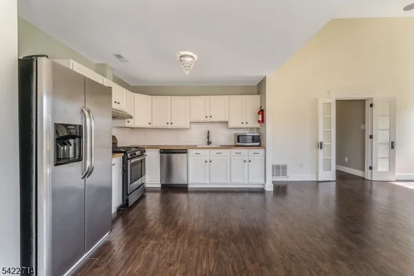 a kitchen with stainless steel appliances a refrigerator sink and cabinets