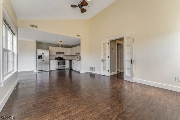 an empty room with wooden floor table and chairs